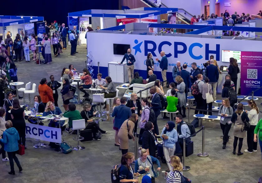 Busy scene in exhibition hall, with RCPCH signage