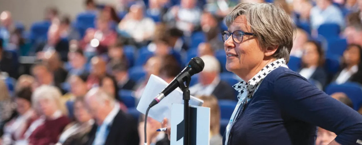Person stood with microphone in busy lecture