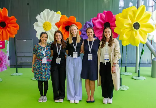group of young people in front of fake flowers