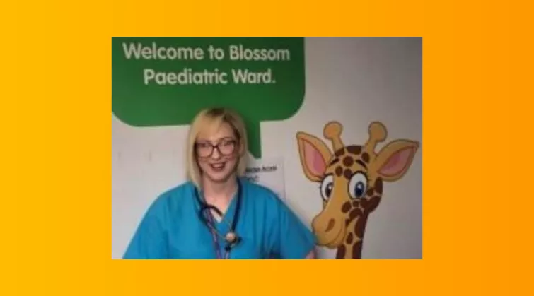 Eimear McCorry, in front of mural - Welcome to Blossom Paediatric Ward