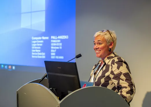 Speaker behind a lectern, with screen behind 