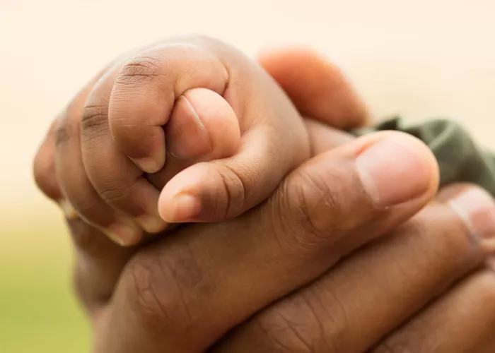 Adult hand holding child's hand