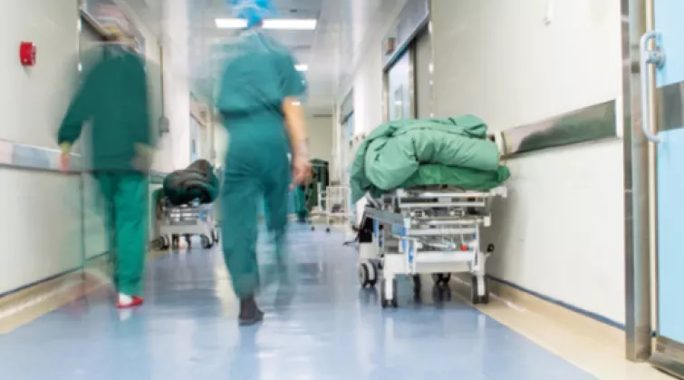Health professionals in scrubs walking down hospital corridor