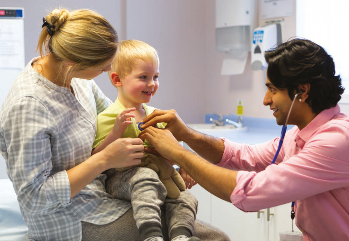 Doctor examining a small child with his parent