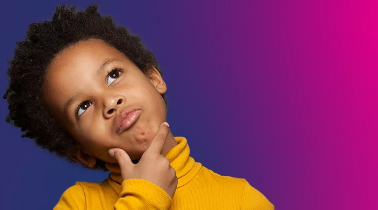 Young boy holds his chin and looks up thoughfully