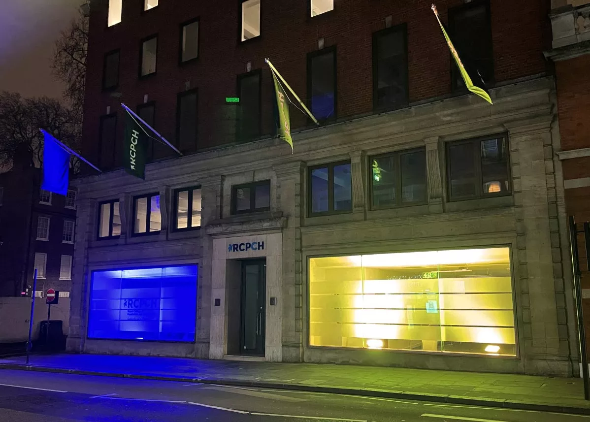 College building lit up in blue and yellow