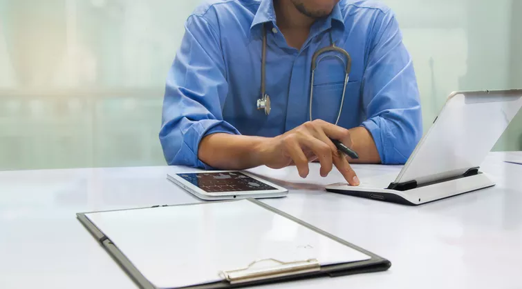 Man at laptop with notes