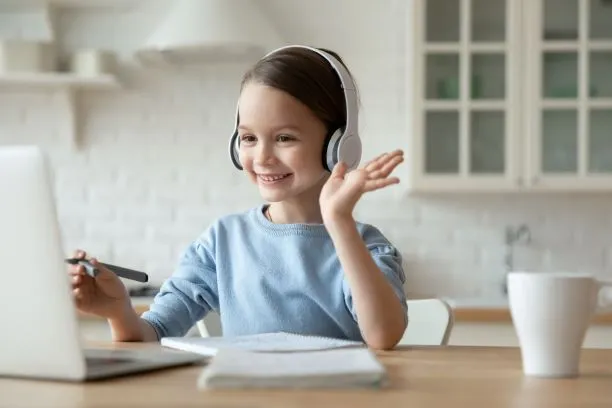 Girl wearing headphones look at laptop, smiling