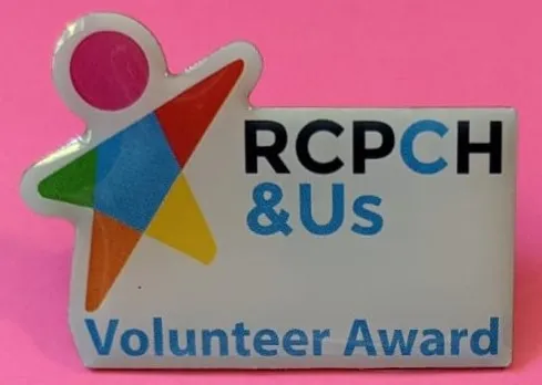 pink background showing a white badge which says RCPCH &Us volunteer award with a colourful child icon on the left