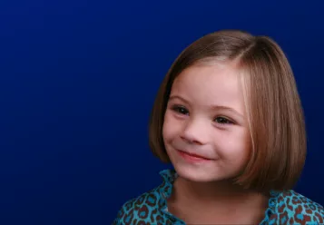 Young girl looks out, on blue background