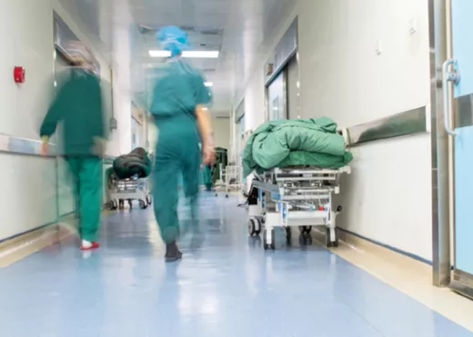 Health professionals in scrubs walking down hospital corridor