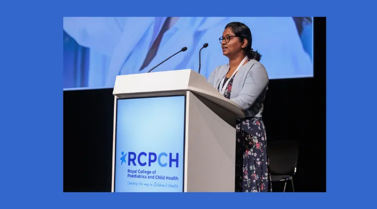 Dr Sharmila Manivannan speaking from podium with RCPCH logo 