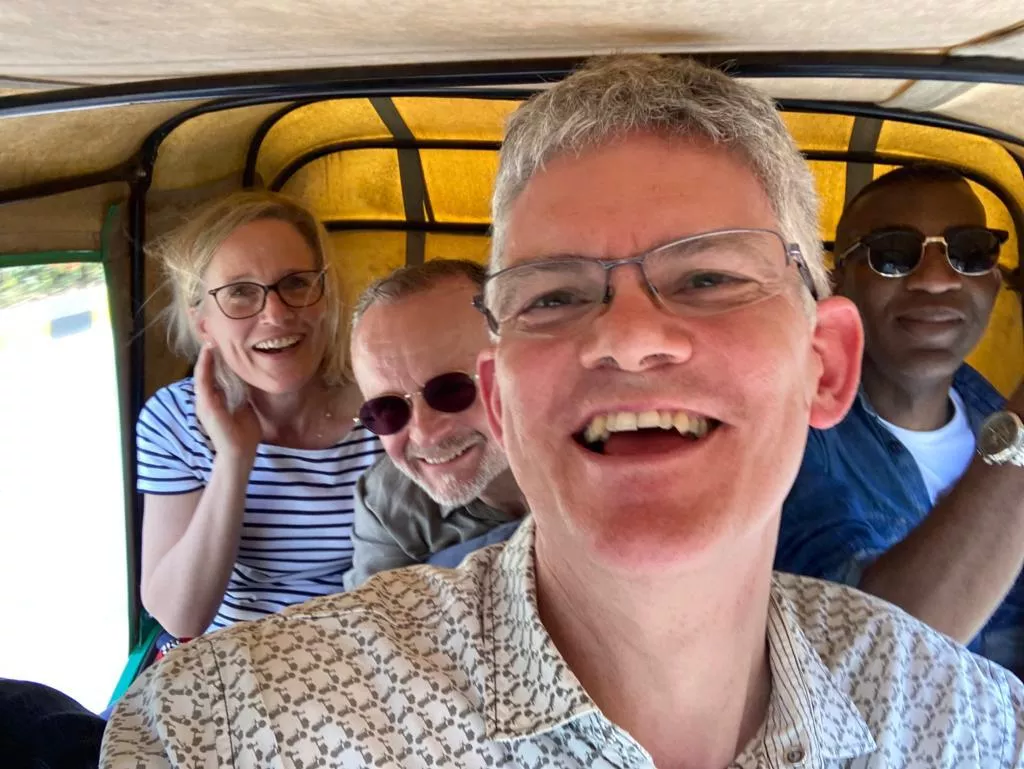 Camilla, Mike, Jonathan and Rob all smiling whilst taking buggy transport 