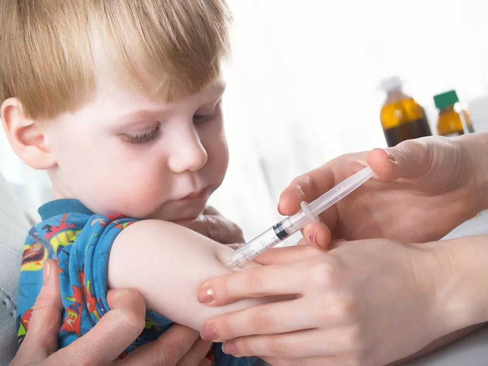 Young boy getting vaccinated in his arm