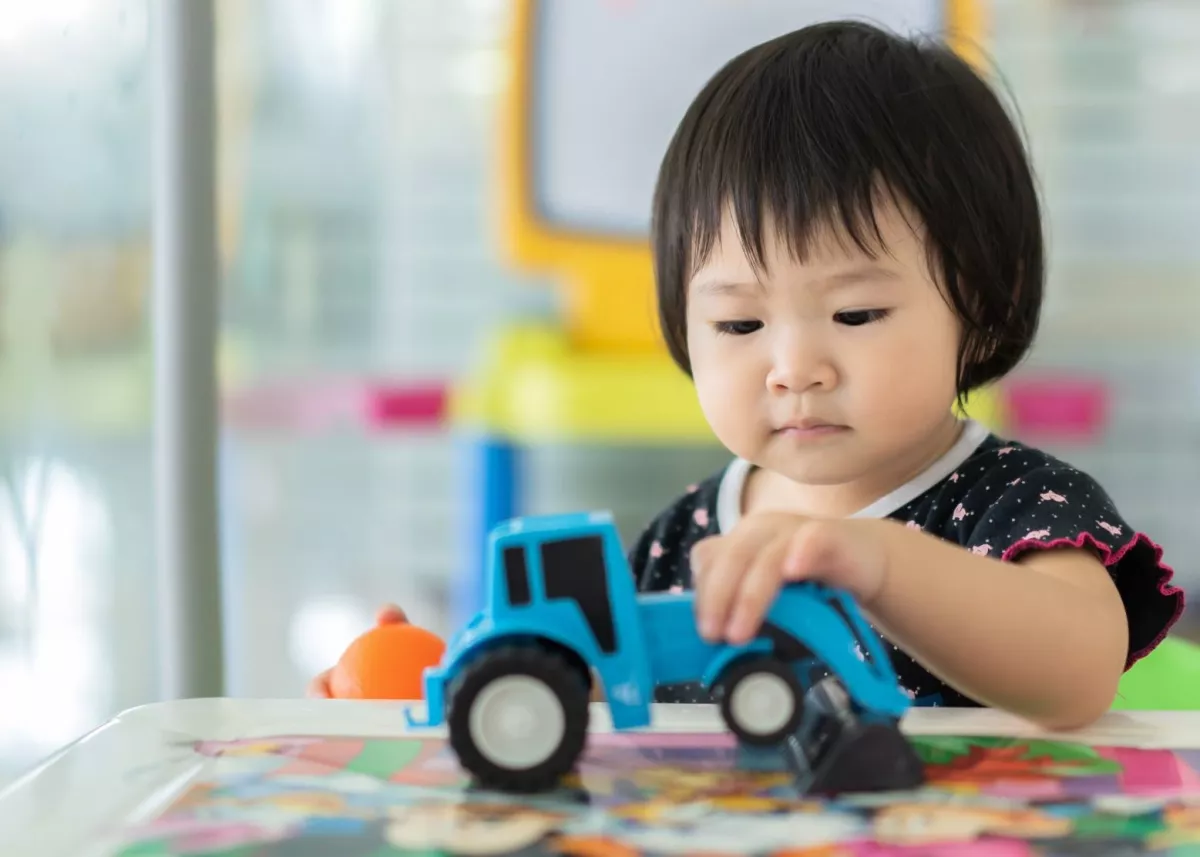 Young girl plays with a tractor