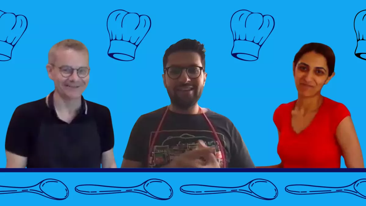 Picture of Mike, Ash and Jaspreet from their bake off episode on a blue back ground with some wooden spoons and chef hats