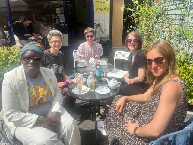 Group of people sitting around an outside table