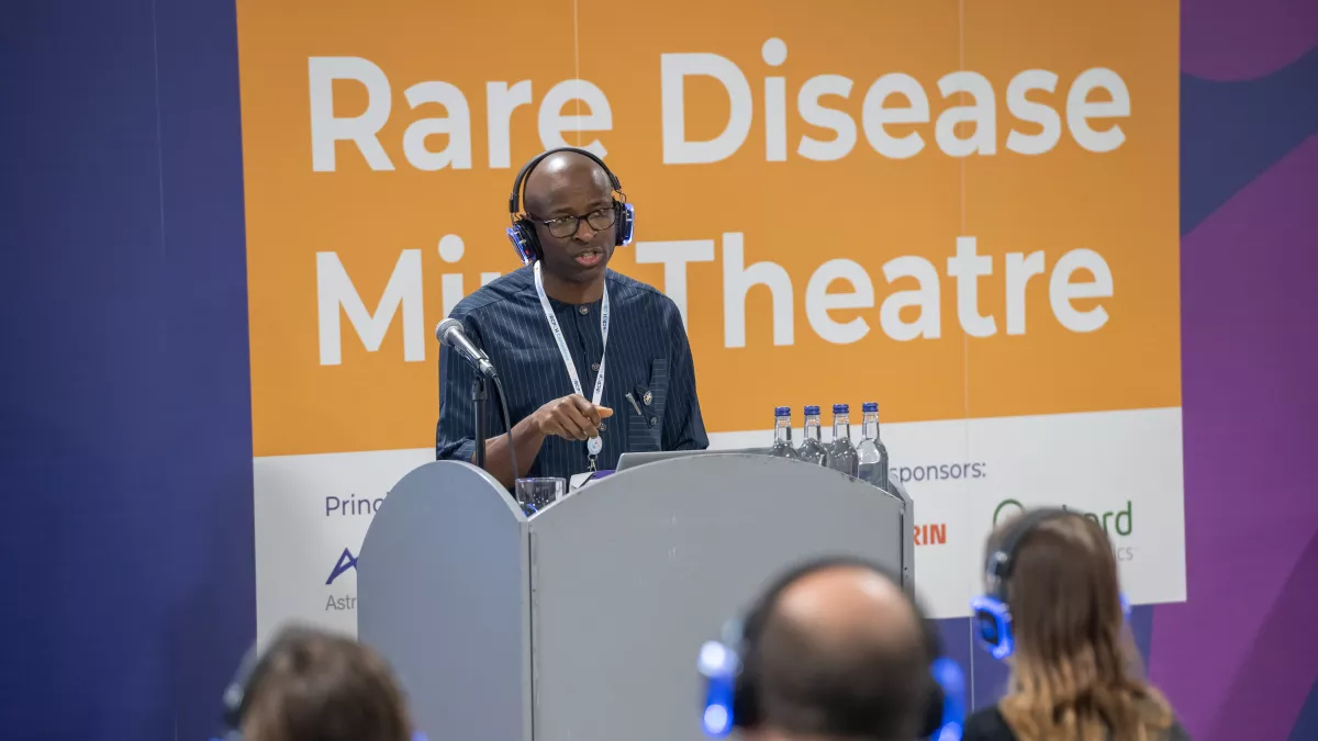 Man presenting in front of sign, Rare Disease Mini Theatre