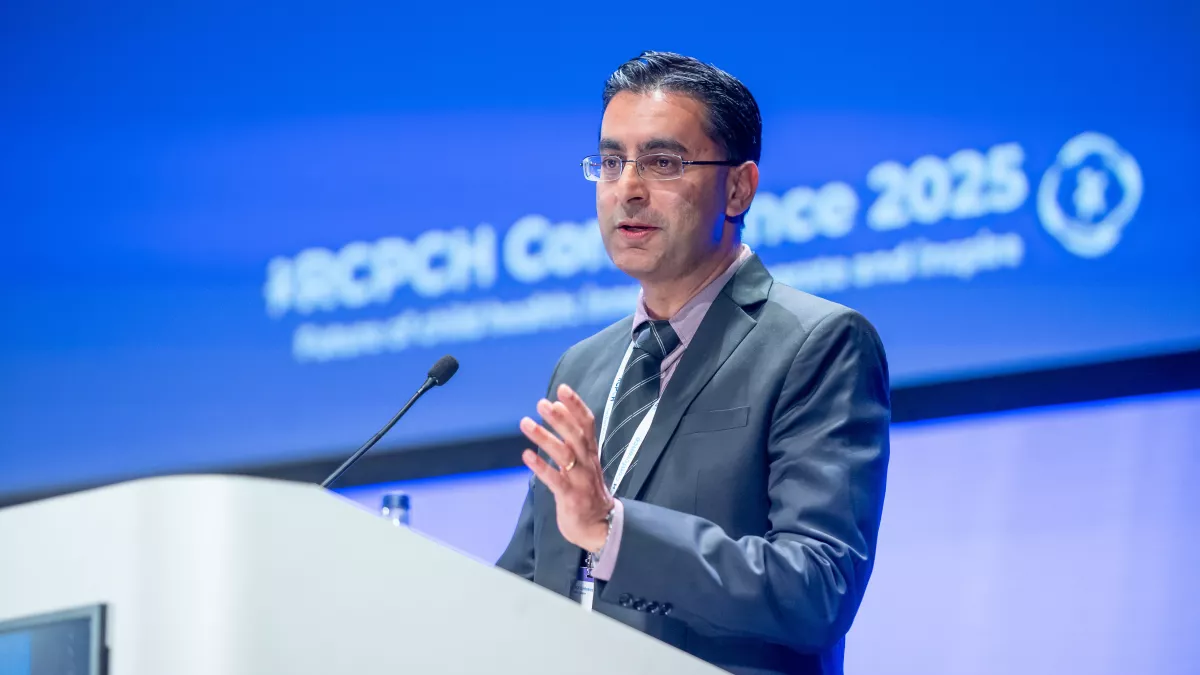 Professor Nitin Kapur speaking on stage, with RCPCH Conference 2025 slide in background