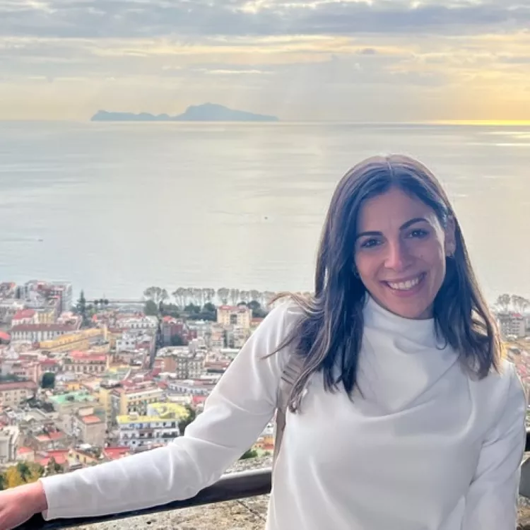 Photo of Maria Neocleous, with a city and the sea behind