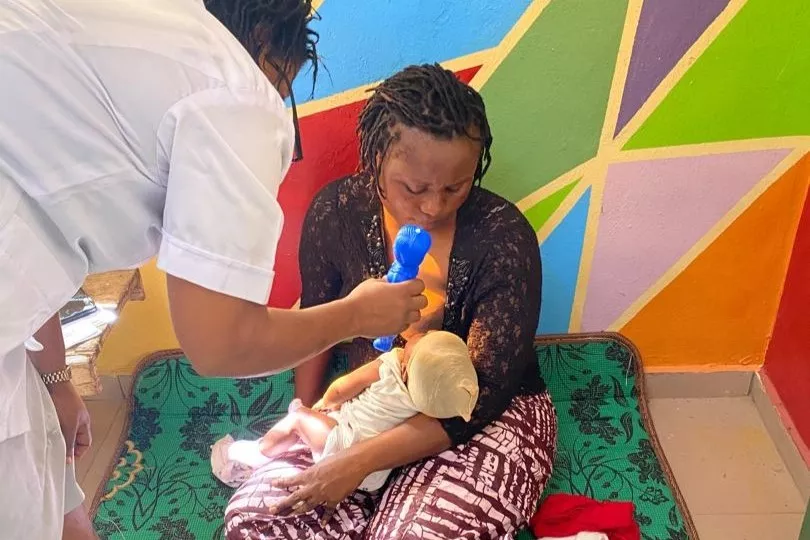 A nurse assesses a baby's response to sound during a developmental screen at a primary healthcare centre