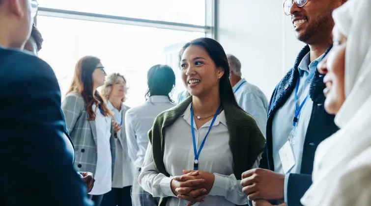 Group of people wearing lanyards and talking in a group