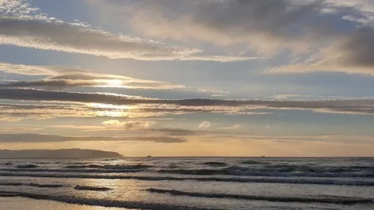 Morning sun over sea, with clouds