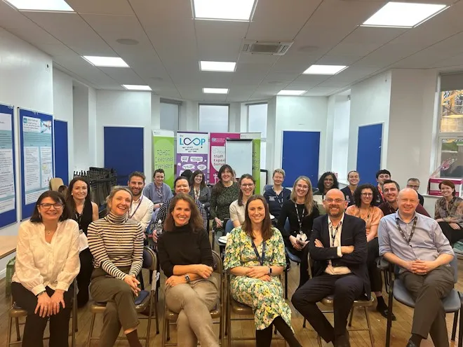 Group of people seated in an office with noticeboards