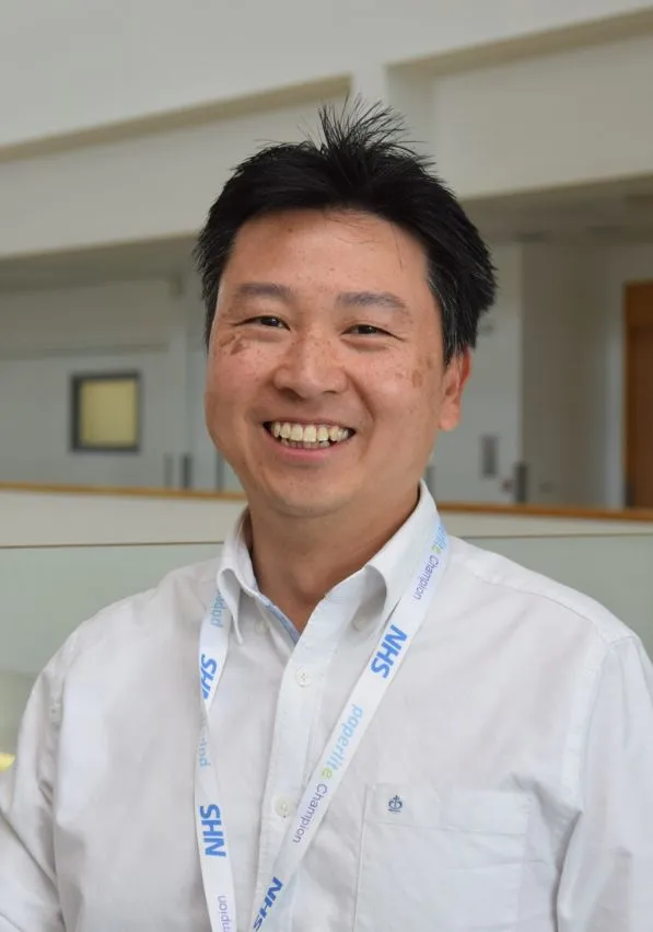 Photo of Yincent Tse smiling, wearing a conference lanyard 