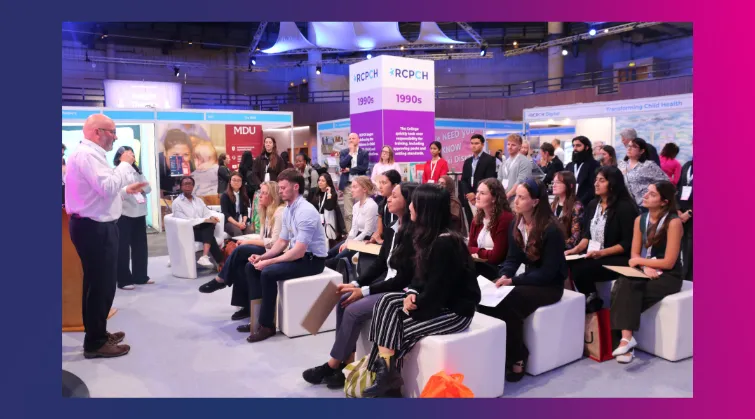 Man presents to audience at a stand in a busy exhibition hall, with RCPCH signage