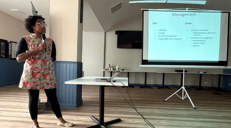Dr Manisha Natarajan presents in front of projector