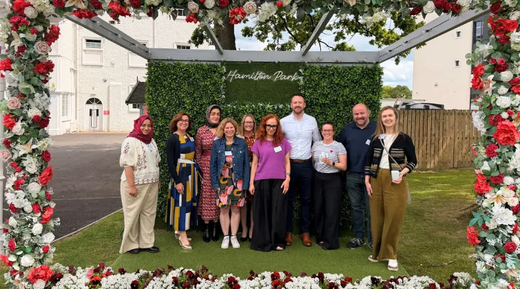 Group photo of the executive committee posed inside a flower display