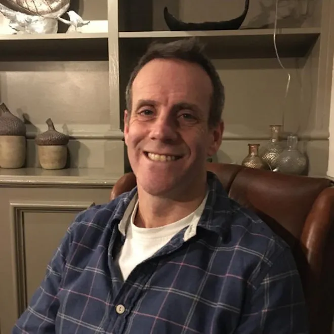 Dr Oliver Rackham smiling in a chair