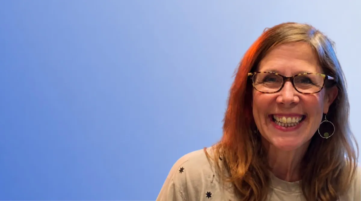 Headshot of Dr Debbie Box smiling on a blue background
