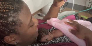 Photo of woman holding her small baby in a hospital environment