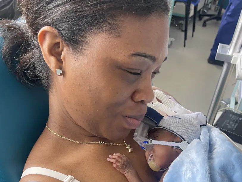 Photo courtesy of Zainab Yunus Close up of woman holding her young baby in a neonatal ward