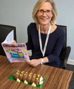 Dr Camilla Kingdon reading milestones with celebratory cake!